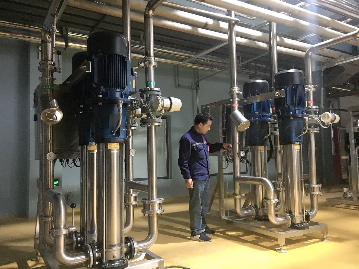 Engineer beside WONE pump stations in a plant room